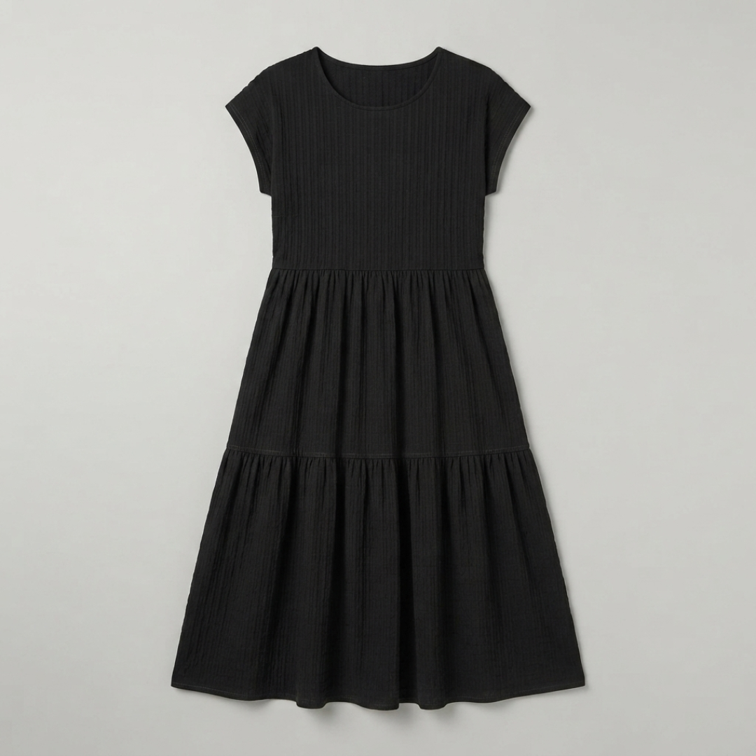 A black short-sleeve tiered dress with a textured, ribbed fabric, shown flat against a light gray background.