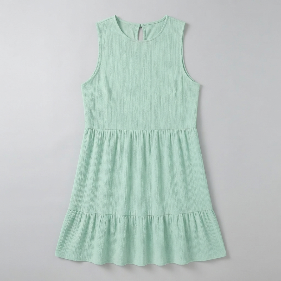 A sleeveless, tiered mini dress in a light mint green color with a textured crinkle fabric, shown flat against a light gray background.