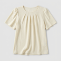 A cream-colored short-sleeve top with a round neckline and vertical pleats on the chest, displayed against a light gray background.