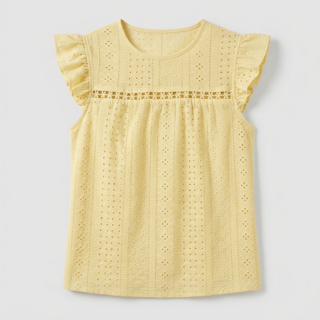 A light yellow eyelet cotton blouse for toddlers, featuring flutter sleeves, a round neckline, and a decorative smocked chest panel, shown flat on a light gray background.